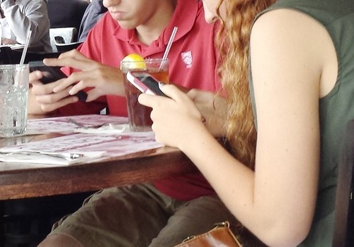 Two teenagers on cellphones