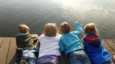 Kids enjoy sunny day lying on dock