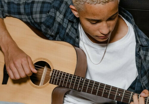 Teen boy strums guitar