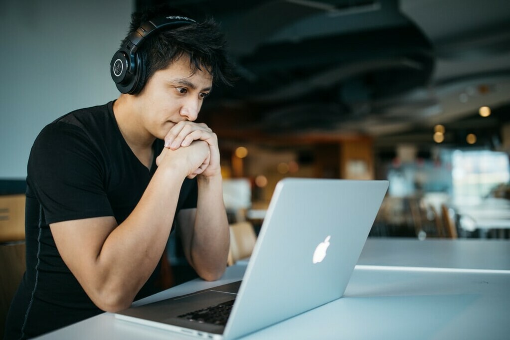 Man in headphones looking at laptop photo by @sickhews on Unsplash