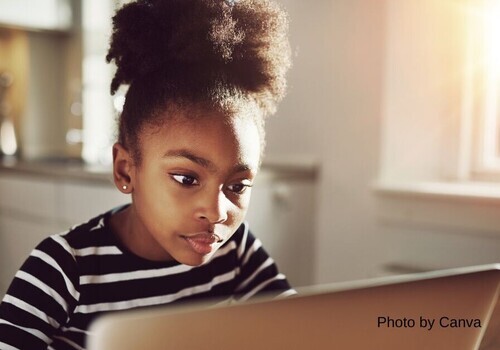 Young girl looks intently at computer screen perhaps contemplating using an AI suggestion in her writing